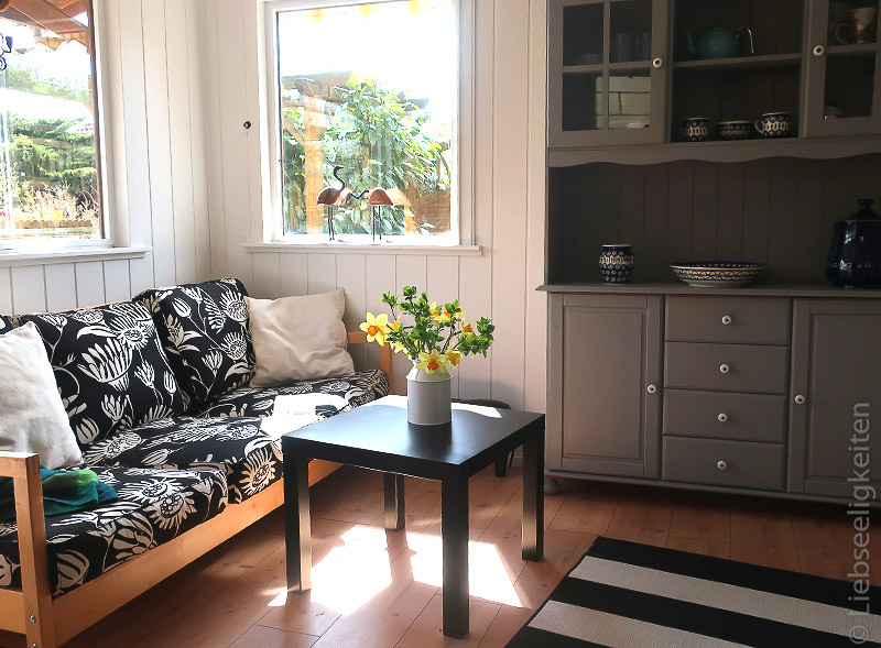 Gartenlaube - Sofa und grau gestrichener Küchenschrank in der Laube
